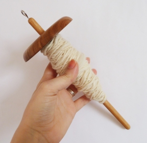 Handmade wooden drop spindle with woolen yarn